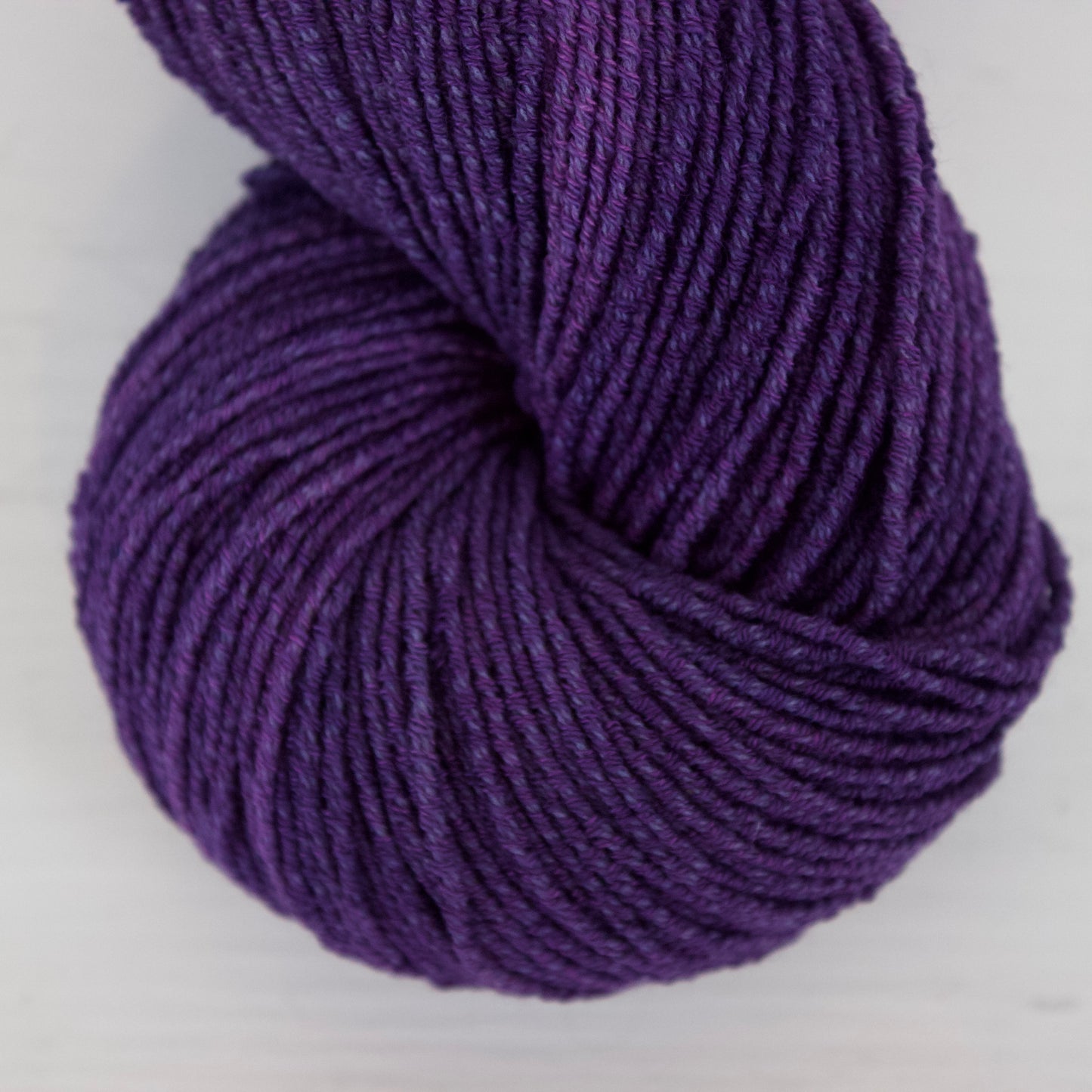 Purple skein of yarn on a white background