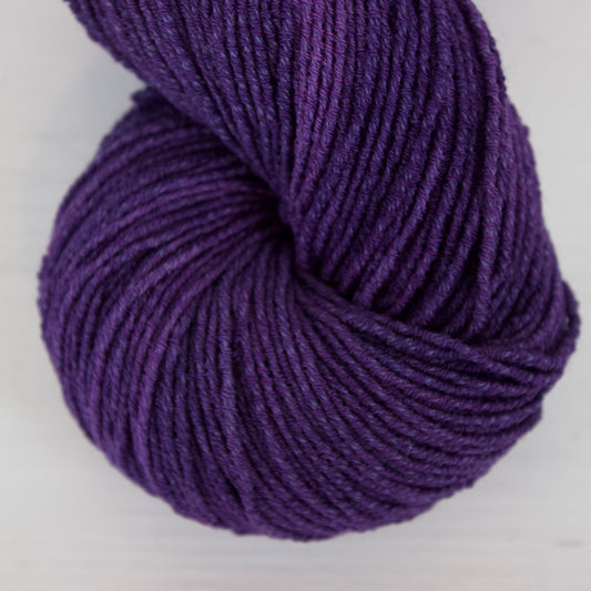Purple skein of yarn on a white background