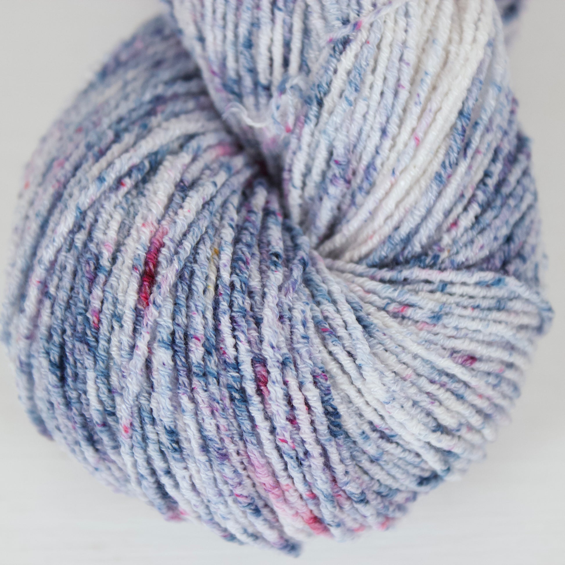 White base yarn with bright indigo and magenta speckles
