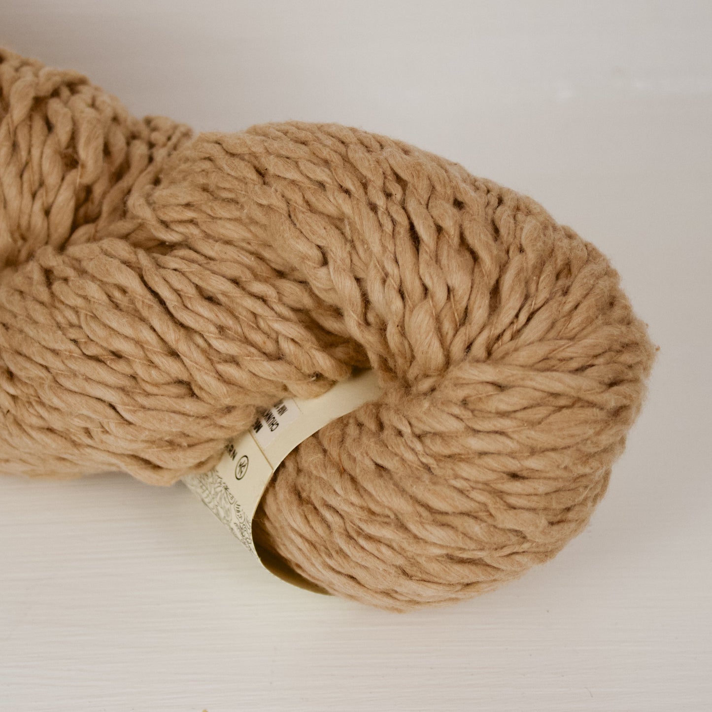 Moka Vega x Pakucho is a thick and thin super bulky that's a natural warm light brown. The skein is large and fluffy.